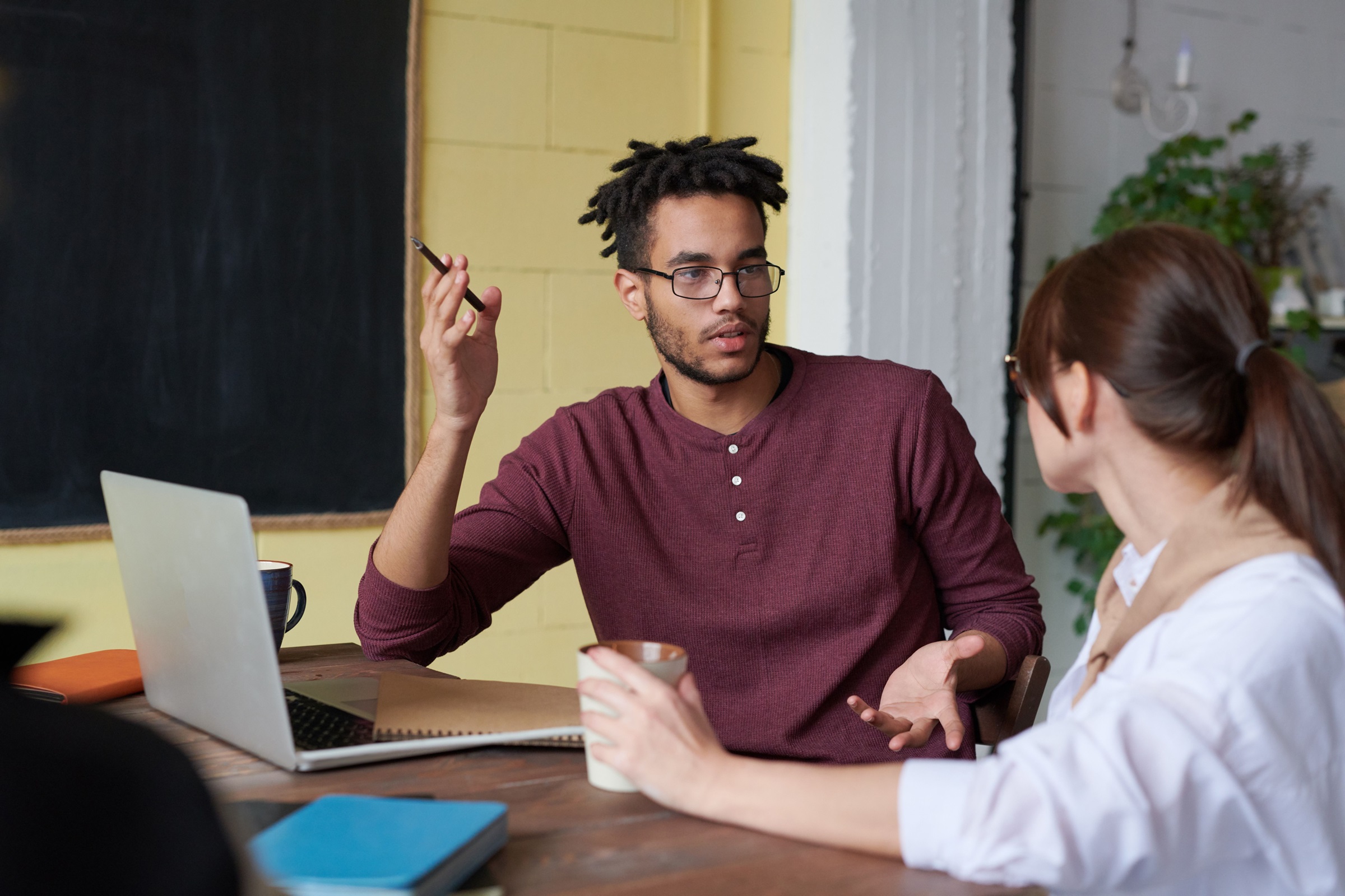 Two colleagues talking through a growth plan at a table