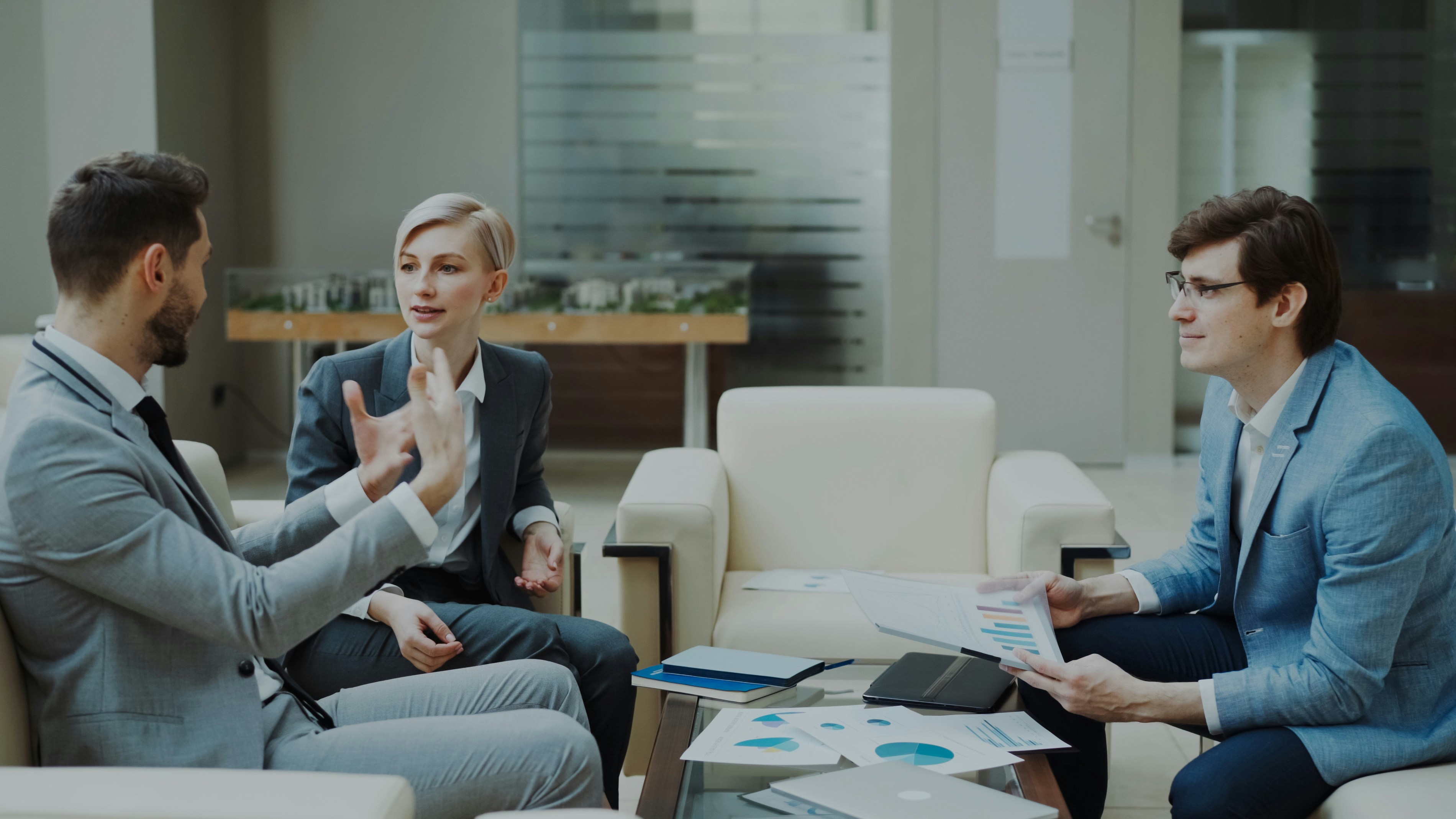 Three people in an advisory conversation in a meeting room